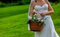 close up of a flower girl a white dress with flowers holding a basket Royalty Free Stock Photo