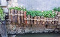 A close-up of the flower pond surrounded by wooden stakes outside the brick wall. Royalty Free Stock Photo