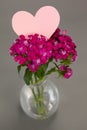 Close-up of flower vase with blank heart shape card Royalty Free Stock Photo