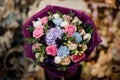 Close-up on flowers of gorgeous bouquet wrapped in purple paper
