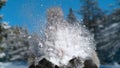 CLOSE UP: Fluffy snowball splatters as it meets unrecognizable woman's face.