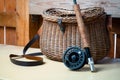 Close up of fly fishing rod with reel next to braided basket. Fly fishing equipment still life. Nobody Royalty Free Stock Photo