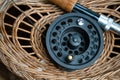 Close up of fly fishing rod with reel next to braided basket. Fly fishing equipment still life. Nobody Royalty Free Stock Photo