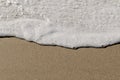 Foamy ocean water on sandy beach Royalty Free Stock Photo