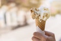Close up focus of female hand holding melting delicious ice cream gelato with sun flare summer, Italy Royalty Free Stock Photo