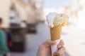 Close up focus of female hand holding melting delicious ice cream gelato with sun flare summer, Italy Royalty Free Stock Photo