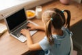 Close-up focus on foreground of thoughtful elementary child school girl doing homework and holding pen against mouth Royalty Free Stock Photo