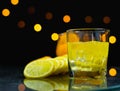 close up focus at ice in lemon juice glass, beside slice fresh lemon on table Royalty Free Stock Photo