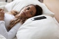 Frightened woman lying in bed looking on smartphone feels Royalty Free Stock Photo