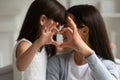 Mothers and daughters fingers showing heart symbol of love