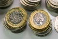 Close up focus photos of new United kingdom Pound coin, among other British coins