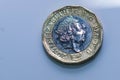 Close up focus photos of new United kingdom Pound coin, among other British coins