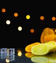 close up focus at slice fresh lemon, beside glass, ice, slice fresh orange Royalty Free Stock Photo