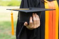 Close up focus of university graduate holds degree certificate and graduation cap celebrates in the  graduation ceremony. Royalty Free Stock Photo