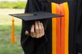 Close up focus of university graduate holds degree certificate and graduation cap celebrates in the  graduation ceremony. Royalty Free Stock Photo