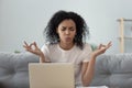 Focused african American woman meditating breathing deep