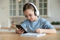 Close up focused little girl wearing headphones using phone Royalty Free Stock Photo