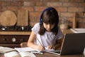 Close up little girl wearing headphones writing notes, studying online Royalty Free Stock Photo