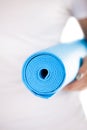 Close up: folded blue yoga mat in woman hands