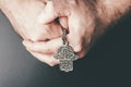 Close-up of folded hands holding Hamsa amulet also known as Hand of Fatima