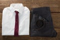 Folded school uniform, belt and spectacle on wooden plank