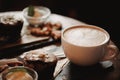 Close up food image of cup of coffee and dessert on the wooden table background in cafe. Trend warm toning. Photo with a small dep Royalty Free Stock Photo