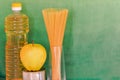 Close-up of food items: canned food, pasta, vegetable oil, fruit.