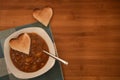 Close up food photography with overhead view of hot homemade chicken soup with love heart shape toast on wood for Valentines Day Royalty Free Stock Photo