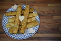 Close up food photography of traditional English homemade cheese straws on a plate with love heart decorations