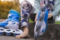 close up on foot of asian kids on the floor taking off or putting on the rollerblade inline skates tying laces while sitting on