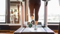 Close up foot sneakers Fitness girl running on track treadmill, Fat woman with muscular legs in exercise gym Royalty Free Stock Photo