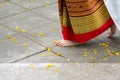 Close up foot step of Thai female dancing, with yellow flower on floor