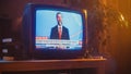 Close Up Footage of a Dated TV Set Screen with Breaking News Report. Handsome Middle Aged Anchorman