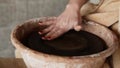 Close up footage of female hands wet the empty potter s wheel surface before work. Sculptor sculpts pots products