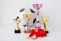 Close up of football ball, golden cups and medals Royalty Free Stock Photo