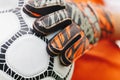 Close up of football soccer player as a goalkeeper holding ball at football goal on field. Soccer boy wearing goalie gloves and Royalty Free Stock Photo