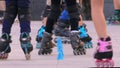 Close up of the footwork of children practicing roller skating.