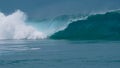 CLOSE UP: Forceful barrel wave splashes ocean water around the coast of Tahiti. Royalty Free Stock Photo