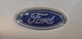 The close up of Ford logotype on brown metallic background.