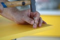 Close-up of foremans hand hammer nail into yellow door Royalty Free Stock Photo