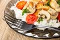 Close up of fork in gray plate with fried chicken meat, mushroom, tomato Royalty Free Stock Photo