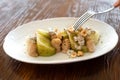 Close-up of a fork poking into a plate of leek salad with meuniere sauce, gourmet style