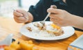 Close-up of a fork and spoon eating rice on a plate