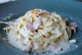 Close up of a fork taking spaghetti with carbonara sauce from a plate. Hot Spaghetti Carbonara on a fork. Italian Royalty Free Stock Photo