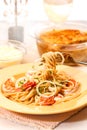 A fork to fetch Spaghetti with prawn and parmesan cheese on dish, traditional Italian food close up vertical view.
