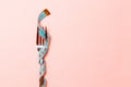 Close up of fork wrapped in measuring tape on pink background. Overweight and overeating concept