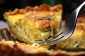 close-up of a forkful of quiche with flaky crust