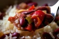 Close-up of a forkful of red beans and rice with diced bell peppers and onions and a sprinkle of cayenne pepper Royalty Free Stock Photo