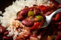 Close-up of a forkful of red beans and rice with diced bell peppers and onions and a sprinkle of cayenne pepper Royalty Free Stock Photo