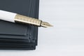Close up of fountain pen on pile of paperwork on white desktop with mock u place. Luxury a,d stationery concept.